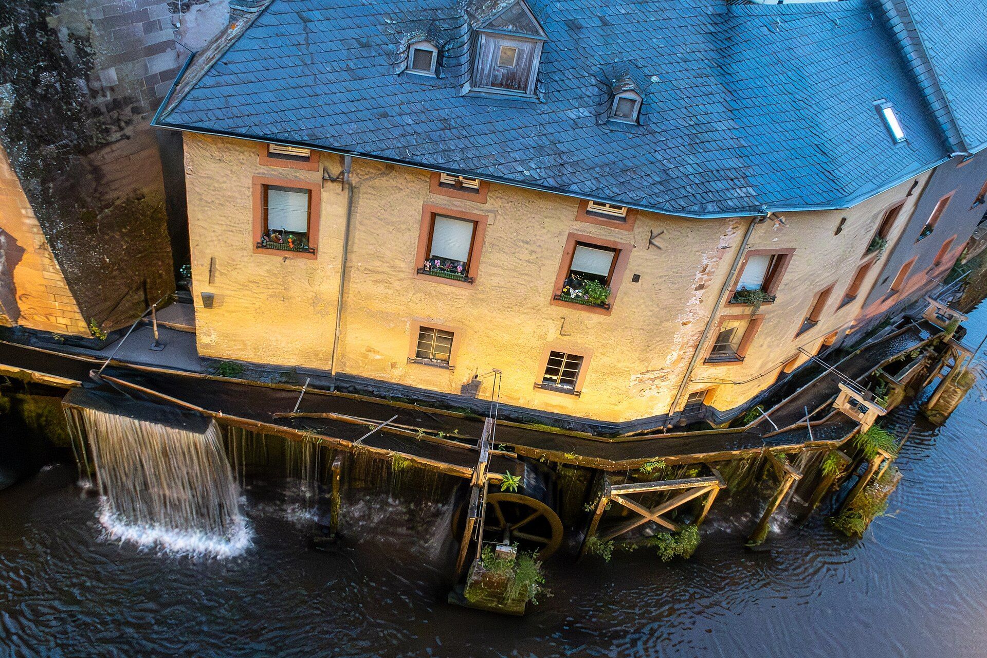 Hackenberger Mühle mit Mühlrad am Leukbach bei Abendbeleuchtung