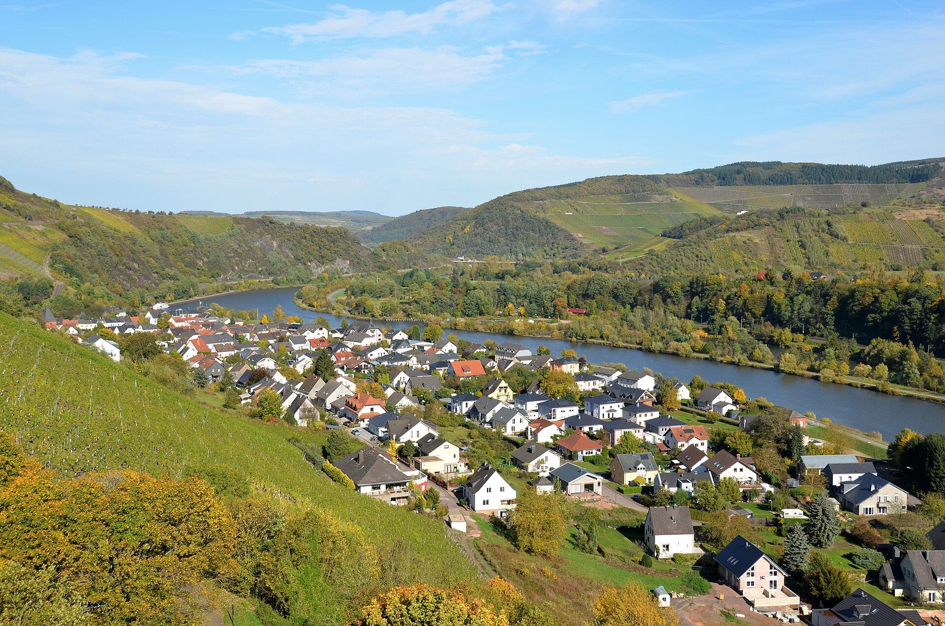 Blick von der Burg auf die Stadt, die Saar und die herbstlichen Weinberge im Hintergrund